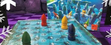Colorful game pieces on a blue game board for "The Magic Labyrinth," a family board game by Dirk Baumann, featuring a whimsical design and hidden pathways. The game box is visible in the background, showcasing its enchanting artwork.