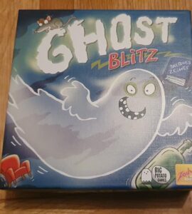 Image of the board game "Ghost Blitz" featuring a playful ghost character on the box cover, designed by Jacques Zeimet and published by Big Potato Games. The box is colorful with illustrations of a mouse, a green bottle, and a red chair, set against a blue background, emphasizing a fun and spooky theme.