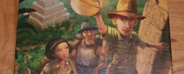 Box cover of the board game "Karuba" by Rüdiger Dorn, featuring four adventurers in an ancient jungle setting, with a temple in the background and a treasure in the foreground, published by HABA.