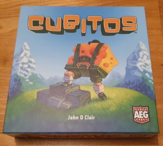 Box cover of the board game "Cubitos" by John D. Clair, featuring a character with a cheese-themed backpack standing on rocks, set against a vibrant landscape with mountains and greenery. The game's logo and publisher's emblem are prominently displayed.