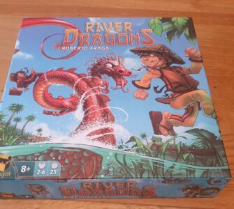 Colorful board game box for "River Dragons" by Roberto Fraga, featuring a boy in a straw hat and a dragon amidst a river scene with tropical plants. Game details indicate it's suitable for ages 8+, for 2-6 players, with a playtime of approximately 25 minutes.