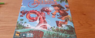 Colorful board game box for "River Dragons" by Roberto Fraga, featuring a boy in a straw hat and a dragon amidst a river scene with tropical plants. Game details indicate it's suitable for ages 8+, for 2-6 players, with a playtime of approximately 25 minutes.