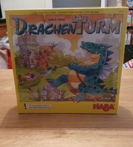 Drachen Turm board game box featuring colorful artwork of a dragon and a whimsical castle, designed by Carlo A. Rossi, published by HABA. Ideal for cooperative play and memory skills development.