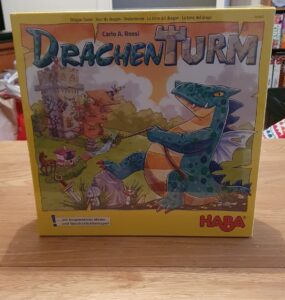 Drachen Turm board game box featuring colorful artwork of a dragon and a whimsical castle, designed by Carlo A. Rossi, published by HABA. Ideal for cooperative play and memory skills development.