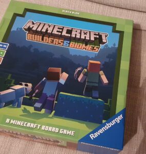 Minecraft Builders & Biomes board game box featuring characters and a dog, designed for 2-4 players aged 10 and up, with a playtime of 30-50 minutes, published by Ravensburger.