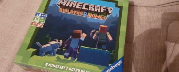 Minecraft Builders & Biomes board game box featuring characters and a dog, designed for 2-4 players aged 10 and up, with a playtime of 30-50 minutes, published by Ravensburger.