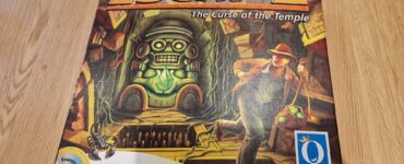 Board game "Escape: The Curse of the Temple" by Queen Games, featuring a vibrant cover illustration of an adventurer navigating a temple with a totem and treasure.