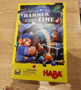 Colorful board game box for "Hammer Time," featuring vibrant illustrations of miners and gemstones, designed for 2-4 players aged 5 and up, by HABA. The box highlights the game's objective to mine and collect gemstones.