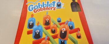 Colorful Gobblet Gobblers game box featuring playful characters and game components, designed for ages 5 and up, suitable for 2 players with a quick 5-minute playtime.