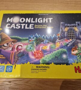 Colorful board game box for "Moonlight Castle" by HABA, featuring a whimsical wizard, enchanted jewels, and a castle backdrop. Designed for 2-4 players aged 5 and up, this game invites players to reclaim magical gems in a charming fantasy setting.