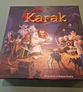 Board game "Karak" box featuring colorful artwork of heroes and skeletons, designed by Petr Mikša and Roman Hladík, published by Kosmos.