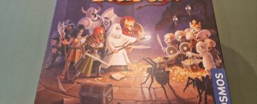 Board game "Karak" box featuring colorful artwork of heroes and skeletons, designed by Petr Mikša and Roman Hladík, published by Kosmos.