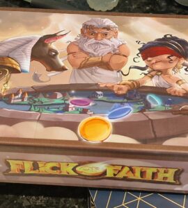 Colorful board game box for "Flick of Faith," featuring mythological characters including gods and a sphinx, with vibrant illustrations and game components displayed.