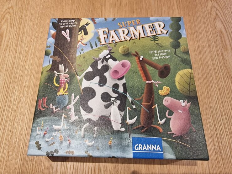 Colorful game box of "Super Farmer" featuring cartoon animals like a cow, pig, and horse, with a farmer character and playful elements, designed for 2-6 players aged 6 and up.