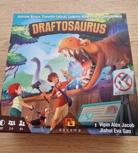 Image of the board game "Draftosaurus" featuring colorful artwork of children interacting with dinosaurs. The game box displays a T-Rex and includes details such as the names of the designers and the recommended age, player count, and playtime, emphasizing its family-friendly gameplay suitable for ages 8 and up.