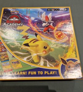 Pokemon Battle Academy board game box featuring Pikachu and an action scene with a character using a fire attack. The design highlights the game’s accessibility with the tagline "Easy to Learn! Fun to Play!" Suitable for ages 6 and up.