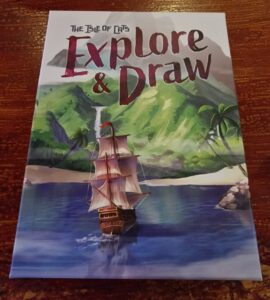 Cover of "The Isle of Cats: Explore & Draw," featuring a colorful illustration of a sailing ship navigating calm waters, surrounded by lush green mountains and tropical palm trees.