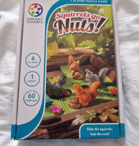 Box of the "Squirrels Go Nuts!" puzzle game by Smart Games, featuring colorful squirrel figurines and acorns on a green base. Designed for one player aged 6 and up, it includes 60 challenges ranging from easy to expert.