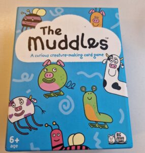 Colorful box of "The Muddles," a creature-making card game for ages 6 and up, featuring whimsical illustrations of various cartoon animals and characters.