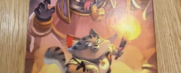 Board game box for "Run Run Run!" featuring vibrant artwork of a heroic cat character and a menacing dog antagonist. Designed for 1-4 players, suitable for ages 8 and up, with an estimated playtime of 30 minutes. Published by The Flying Games.
