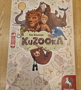 Colorful board game box for "KuZooKa" by Leo Colovini, featuring whimsical animal illustrations including a lion, monkey, sloth, and birds, designed for 2 to 4 players aged 10 and up.