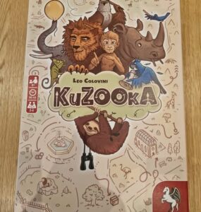 Colorful board game box for "KuZooKa" by Leo Colovini, featuring whimsical animal illustrations including a lion, monkey, sloth, and birds, designed for 2 to 4 players aged 10 and up.
