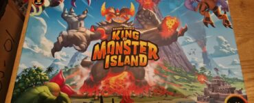 Box cover of the board game "King of Monster Island" featuring colorful artwork of giant monsters, a volcano, and a coastal landscape. Designed by Richard Garfield and Paul Mafavon, suitable for 2-5 players aged 10 and up, with a playtime of 45-60 minutes.