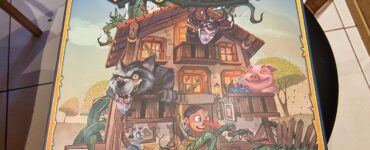 Colorful board game box for "Fairy Tale Inn" featuring whimsical characters like a wolf, a pig, and a wooden puppet, designed by Paolo Mori and Remo Conzadori. The illustration showcases a charming inn surrounded by fairy tale elements.