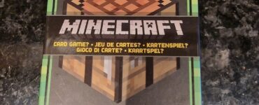 Minecraft card game packaging featuring a TNT block, crafting table, and player instructions. Suitable for 2-4 players aged 8 and up.