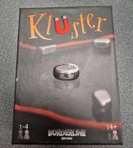 Box of the game "KluSter" by Borderline Editions, featuring a metallic game piece on a dark background, suitable for 1-4 players aged 14 and up.