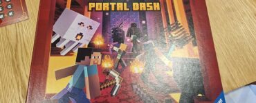 Minecraft Portal Dash board game box featuring characters and elements from the popular game, designed for cooperative play. The artwork showcases Steve, various Minecraft mobs, and dynamic game elements. Suitable for ages 10 and up, published by Ravensburger.