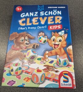 Colorful board game box titled "Ganz Schön Clever Kids" by Wolfgang Warsch, featuring playful illustrations of a dog and a cat, along with dice displaying various symbols. The game is designed for children aged 5 and up, promoting fun and strategic thinking.