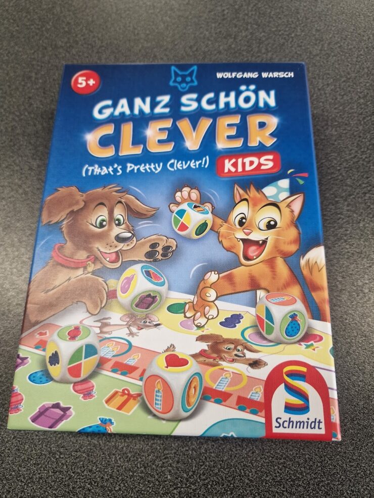 Colorful board game box titled "Ganz Schön Clever Kids" by Wolfgang Warsch, featuring playful illustrations of a dog and a cat, along with dice displaying various symbols. The game is designed for children aged 5 and up, promoting fun and strategic thinking.