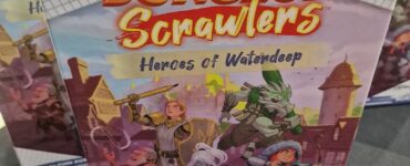 Dungeons & Dragons Dungeon Scrawlers: Heroes of Waterdeep board game box displayed at a gaming convention, featuring colorful artwork of characters preparing for adventure.