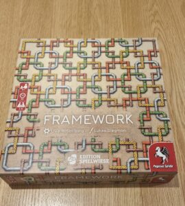 Board game "Framework" by Uwe Rosenberg and Lukas Siegmon, featuring a colorful pipe design on the box cover. Suitable for 1-4 players, ages 8 and up, with a playtime of approximately 30 minutes. Published by Pegasus Spiele.