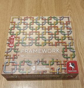 Board game "Framework" by Uwe Rosenberg and Lukas Siegmon, featuring a colorful pipe design on the box cover. Suitable for 1-4 players, ages 8 and up, with a playtime of approximately 30 minutes. Published by Pegasus Spiele.