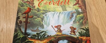 Cover of the board game "My Lil' Everdell," featuring vibrant artwork by Andrew Bosley. The illustration showcases a whimsical forest scene with characters like mice and frogs, a waterfall, and lush greenery, highlighting the enchanting world of Everdell. Perfect for family game nights and young players.