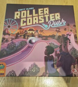 Board game box for "Roller Coaster Rush" by Scott Almes, featuring vibrant artwork of a theme park with roller coasters and attractions. The design includes playful characters enjoying the amusement park atmosphere, highlighting the game's fun and engaging theme. Published by Pandasaurus Games.