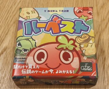 Colorful board game box featuring cartoon fruits and vegetables, with Japanese text and a note indicating that English rules are available. The game is titled "ハーベスト" (Harvest) and is designed for fun and engaging gameplay.