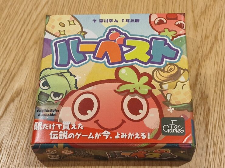 Colorful board game box featuring cartoon fruits and vegetables, with Japanese text and a note indicating that English rules are available. The game is titled "ハーベスト" (Harvest) and is designed for fun and engaging gameplay.
