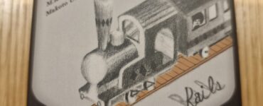 Illustration of a vintage steam locomotive on the packaging of the board game "Rocca Rails," featuring the names of the designers: Tsubasa Okamoto, M. Kakinohihara, and Makoto Ueda.