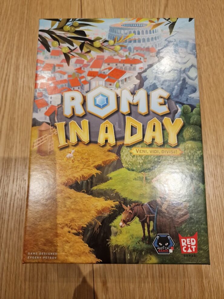 Board game "Rome in a Day" featuring vibrant artwork of ancient Rome, with the tagline "Veni, Vidi, Divisi," designed by Evgeny Petrov, published by Red Cat Games. The cover showcases a picturesque landscape with buildings, greenery, and a horse, set against a backdrop of the iconic Colosseum.