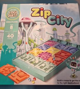 Box cover of the LogiQuest game "Zip City," featuring a futuristic cityscape, a maze-building puzzle with colorful pieces, and a robot character. Designed for single players aged 8 and up, the game includes 40 puzzles that challenge players to navigate marbles to their correct destinations.