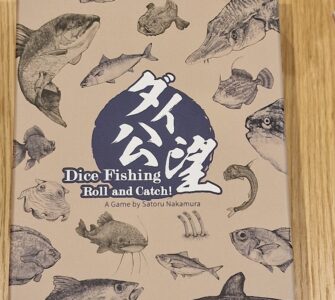 Dice Fishing game box featuring various fish illustrations, titled "Dice Fishing: Roll and Catch!" designed by Satoru Nakamura, set against a light brown background.