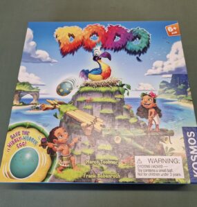 Colorful board game "Dodo" featuring a vibrant dodo bird on a tropical island, with children playing and an egg illustration. Suitable for ages 6 and up, designed by Marco Teubner and Frank Bebenroth, published by Kosmos.