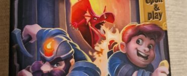 Board game box for "My Gold Mine," featuring two miners in action, one with a pickaxe and the other holding a gold coin, with a dragon in the background. The vibrant artwork showcases a fantasy theme, emphasizing adventure and treasure hunting.