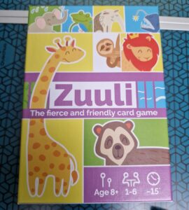 Colorful box of the card game "Zuuli," featuring playful animal illustrations including a giraffe, sloth, lion, and more. The design highlights that the game is suitable for ages 8 and up, supports 1 to 6 players, and has a playtime of approximately 15 minutes.