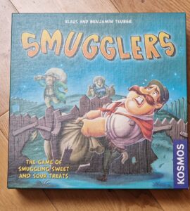 Board game box for "Smugglers," featuring colorful artwork and characters involved in the game of smuggling sweets and sour treats. Published by Kosmos, designed by Klaus and Benjamin Teuber.