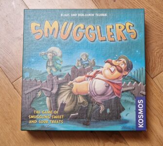 Board game box for "Smugglers," featuring colorful artwork and characters involved in the game of smuggling sweets and sour treats. Published by Kosmos, designed by Klaus and Benjamin Teuber.