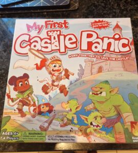 Colorful board game box for "My First Castle Panic," designed for ages 4 and up, featuring children and goblins, emphasizing teamwork in a castle defense theme. Suitable for 1-4 players, it promotes cooperative gameplay.